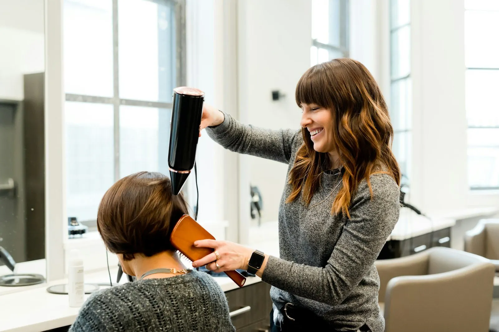 Estilista secando el cabello de una clienta